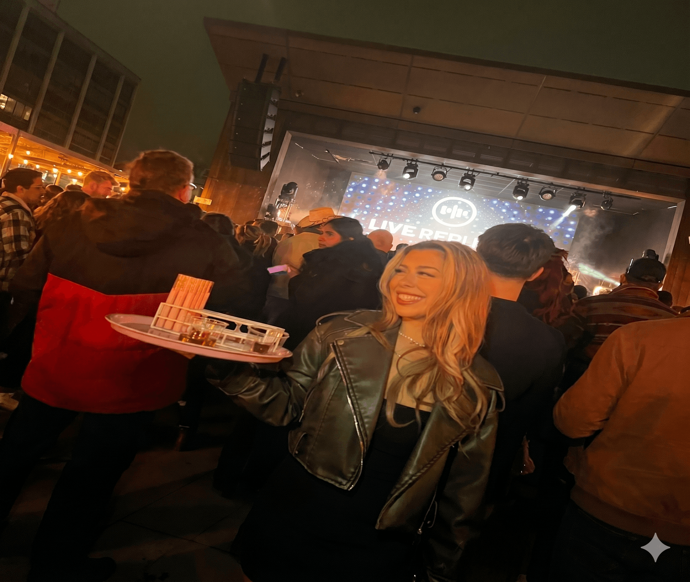 Effervescent hostess carrying a tray of drinks through a venue